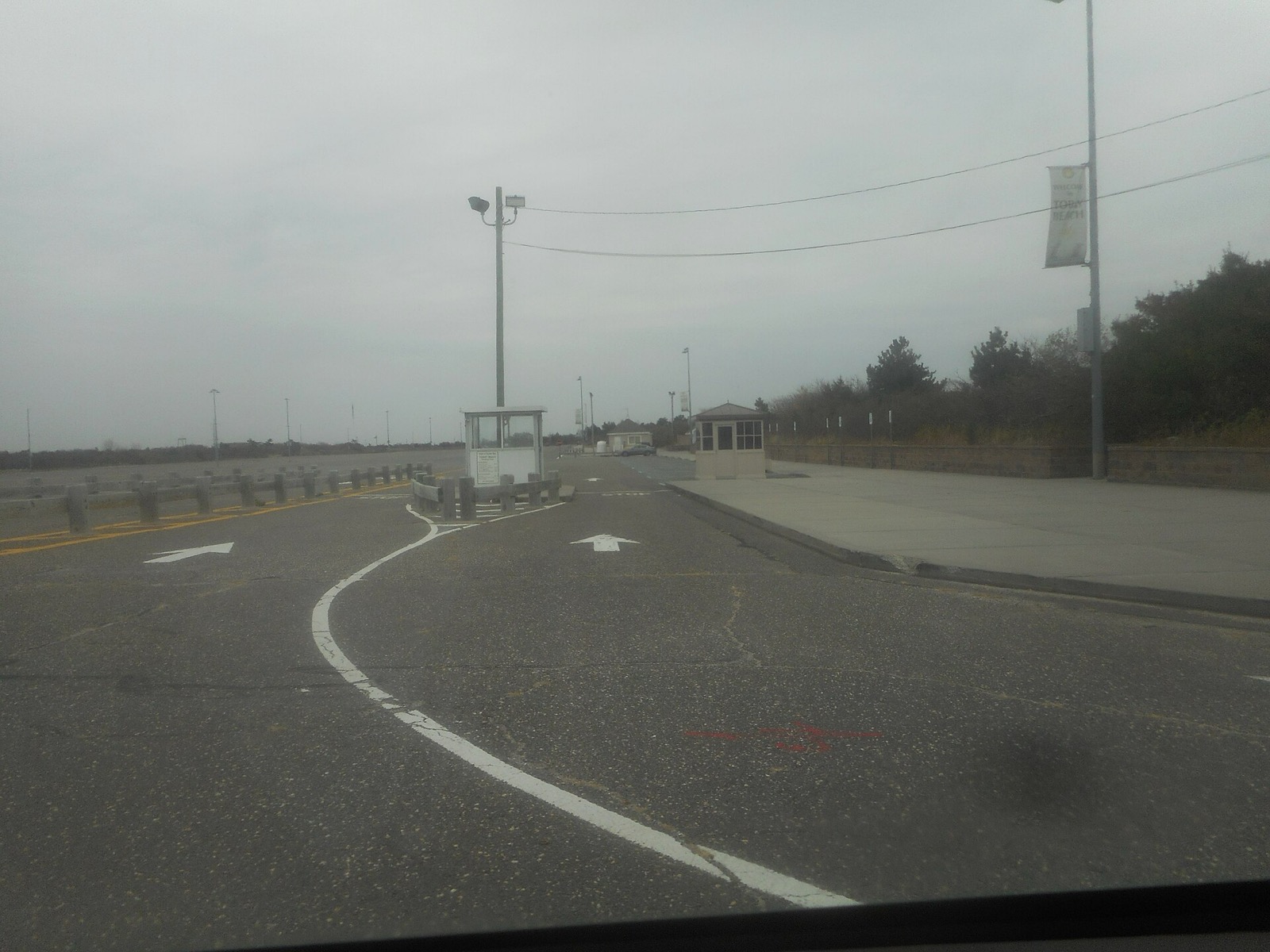 East parking lot toll booth at Tobay Beach, with an entry booth and a barrier arm on the road