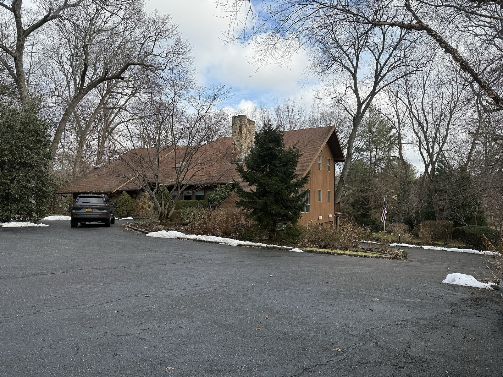 Brookville Village Hall, a low brick building with white trim on a tree-lined street