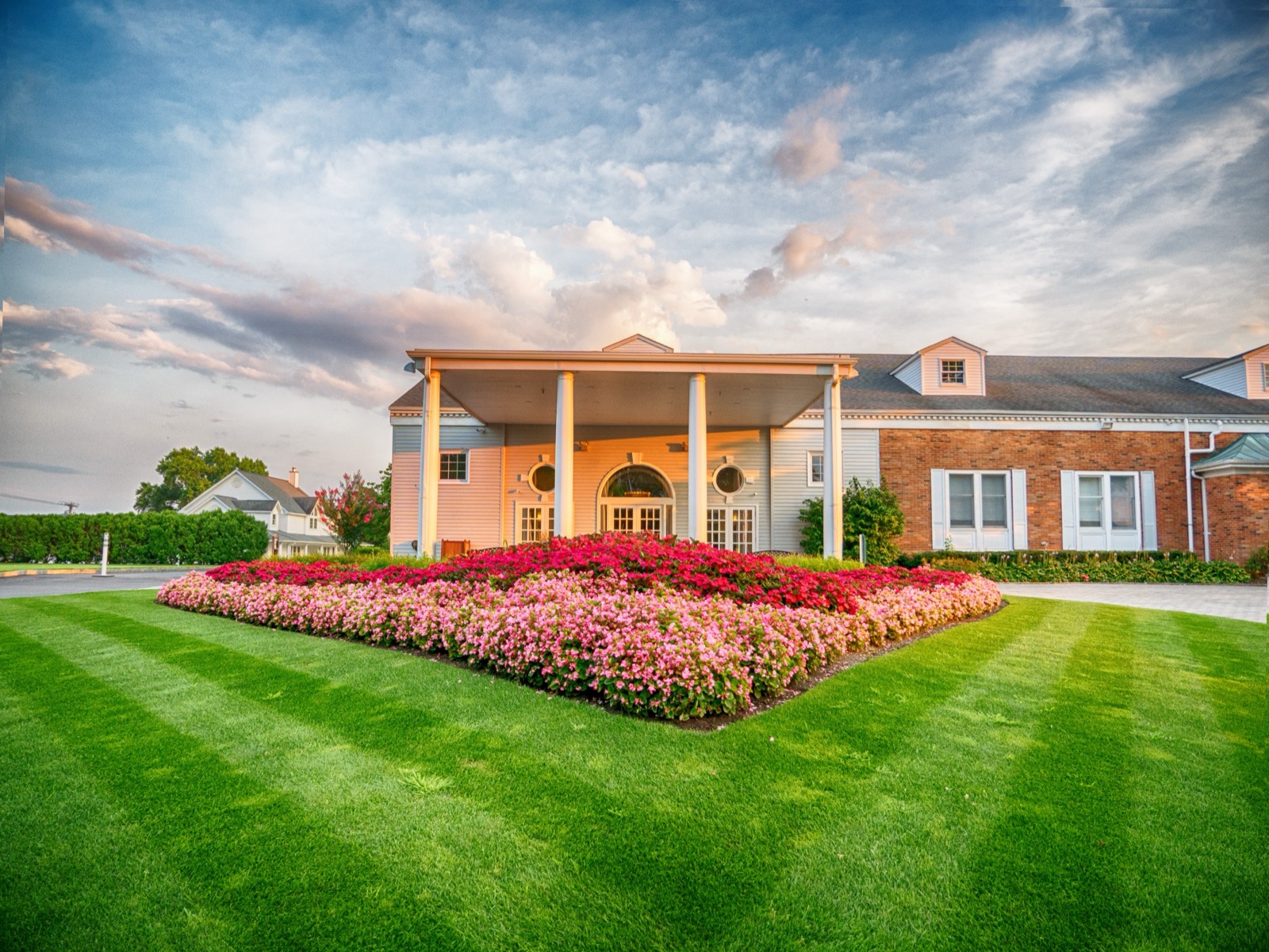 Glen Head Country Club clubhouse with white columned portico and striped lawn