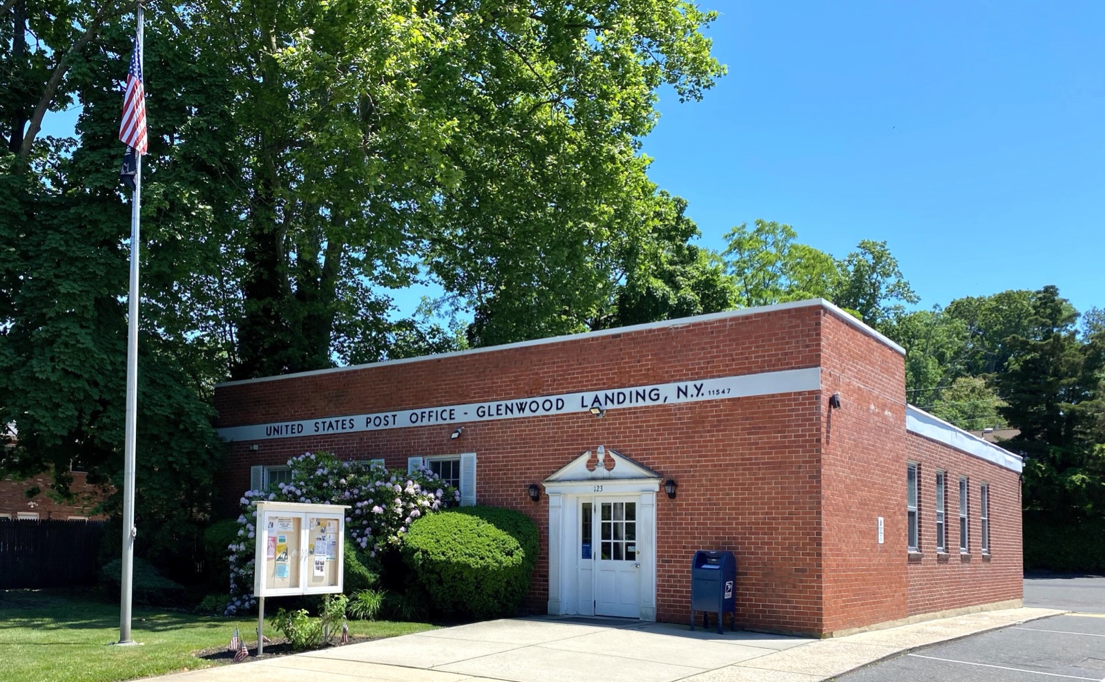 Brick United States Post Office building in Glenwood Landing with flagpole and lawn