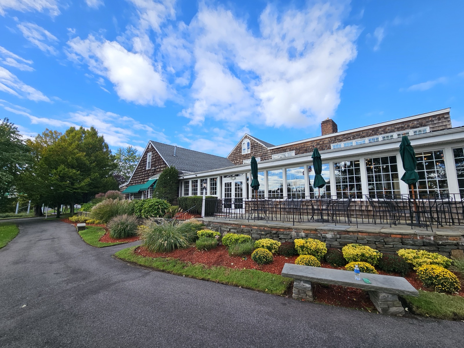 The Milleridge Inn exterior with shingled walls, covered glass dining porch and lawn driveway