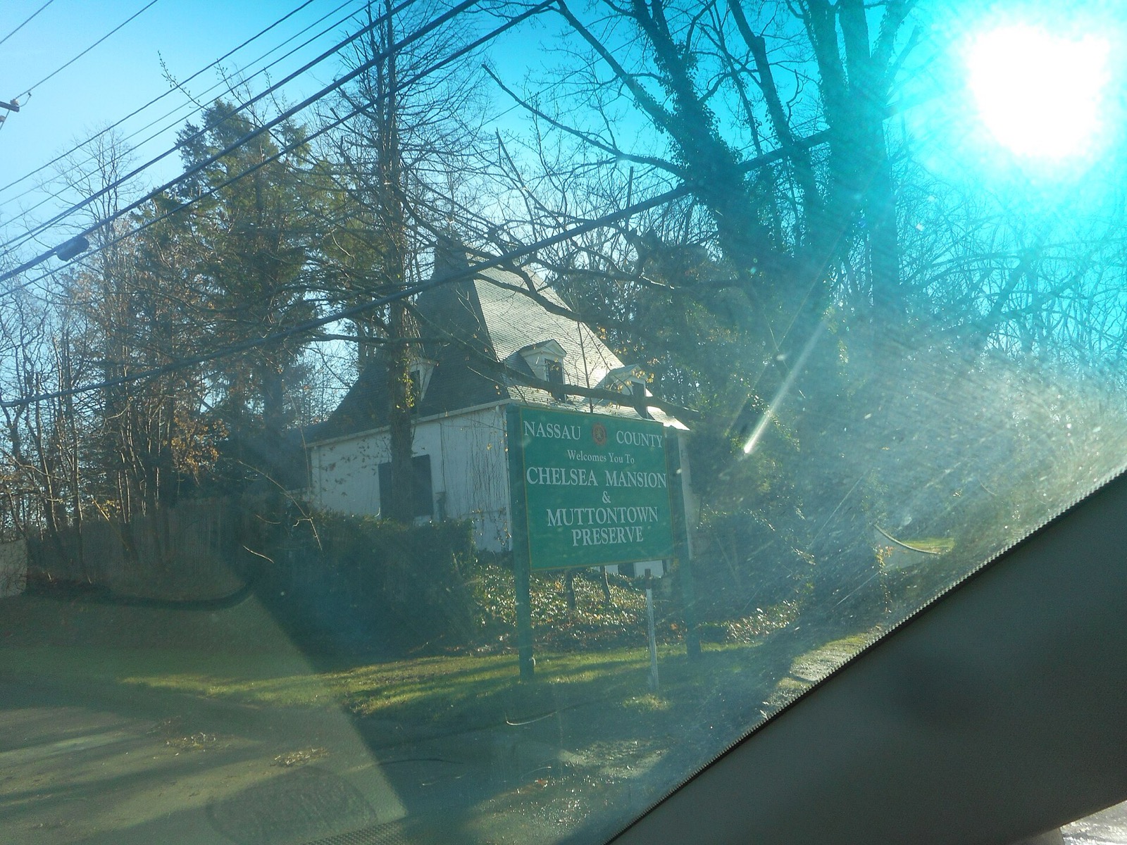 Entrance sign for the Chelsea Mansion and Muttontown Preserve beside the road