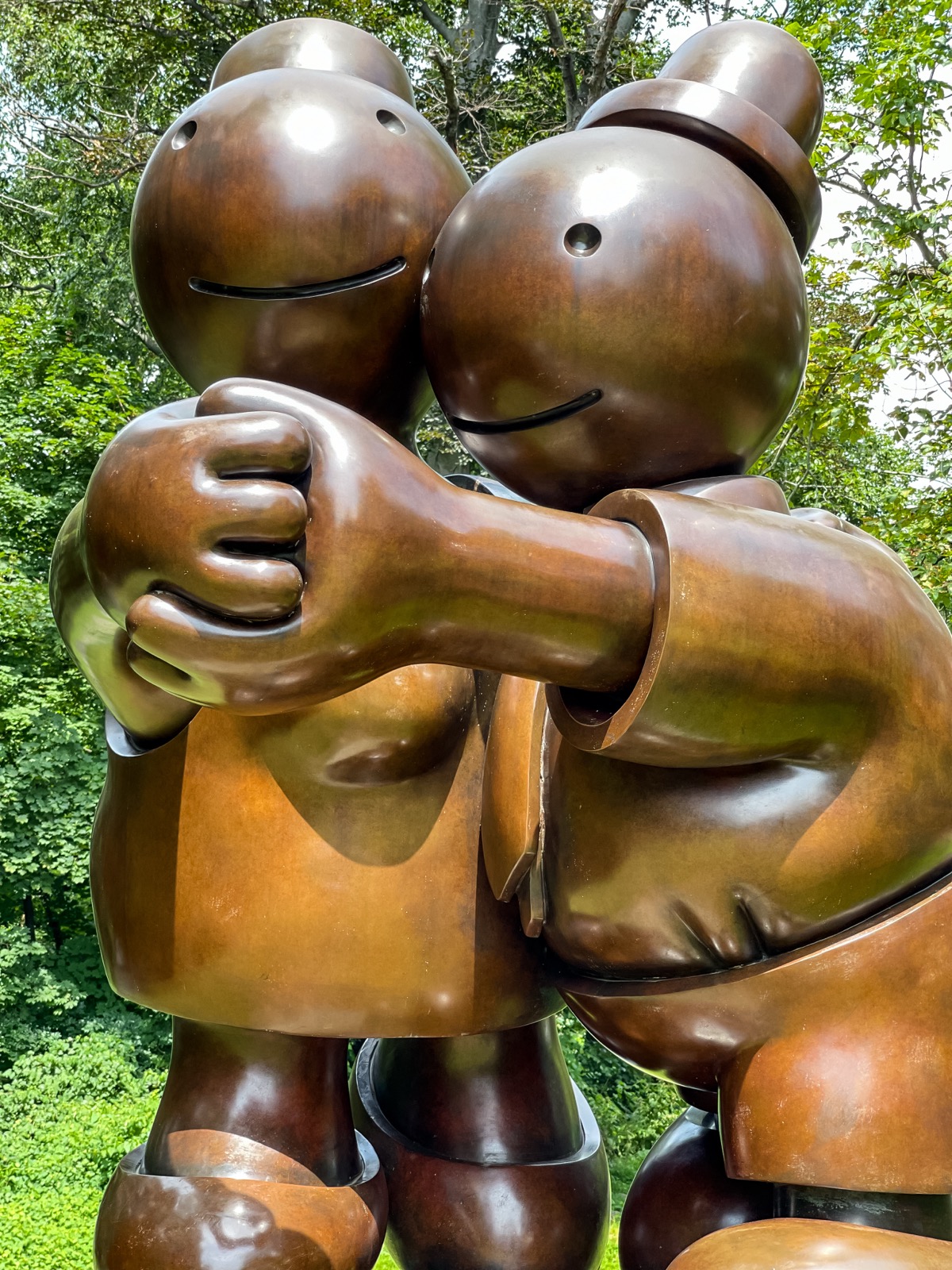 Two large bronze figures embracing in the museum sculpture garden
