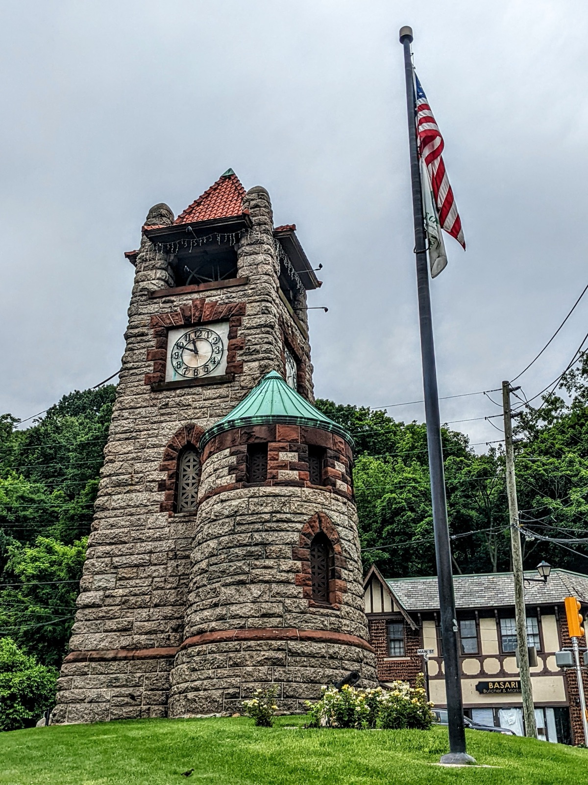 Stone Ellen E. Ward Memorial Clock Tower with green copper roof and flagpole in Roslyn